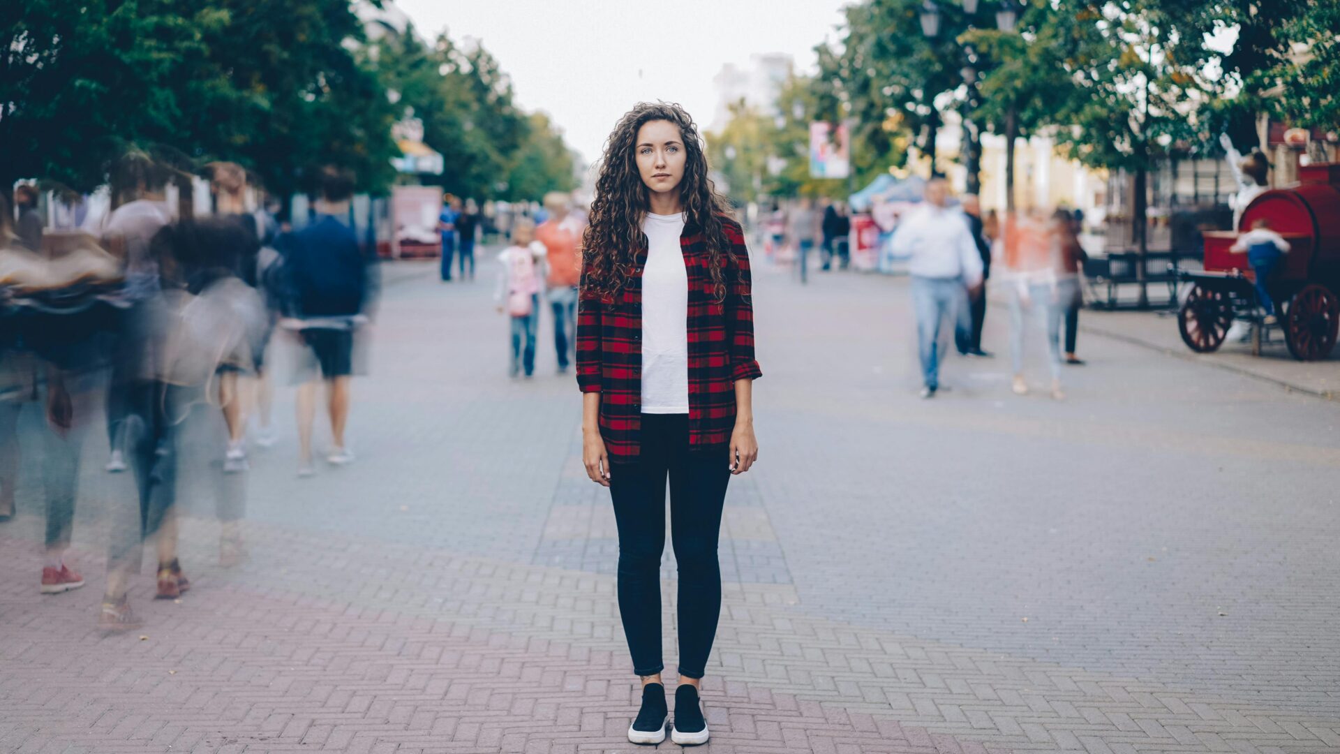 Young woman in urban scene with motion blur of people around her.