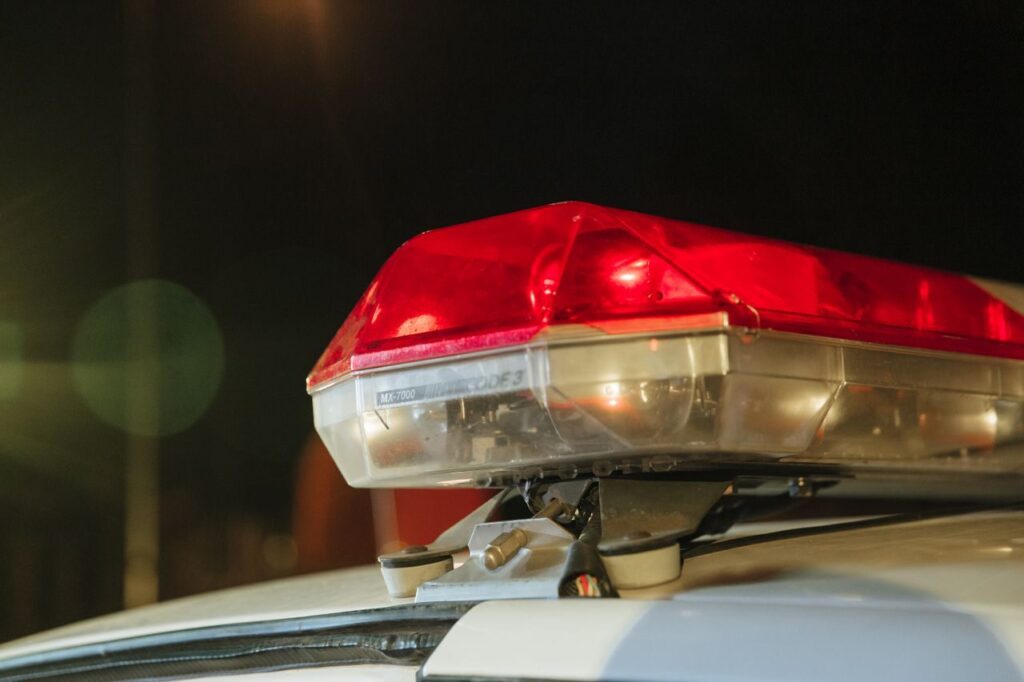 Detailed view of a police car's red siren light shining at night.
