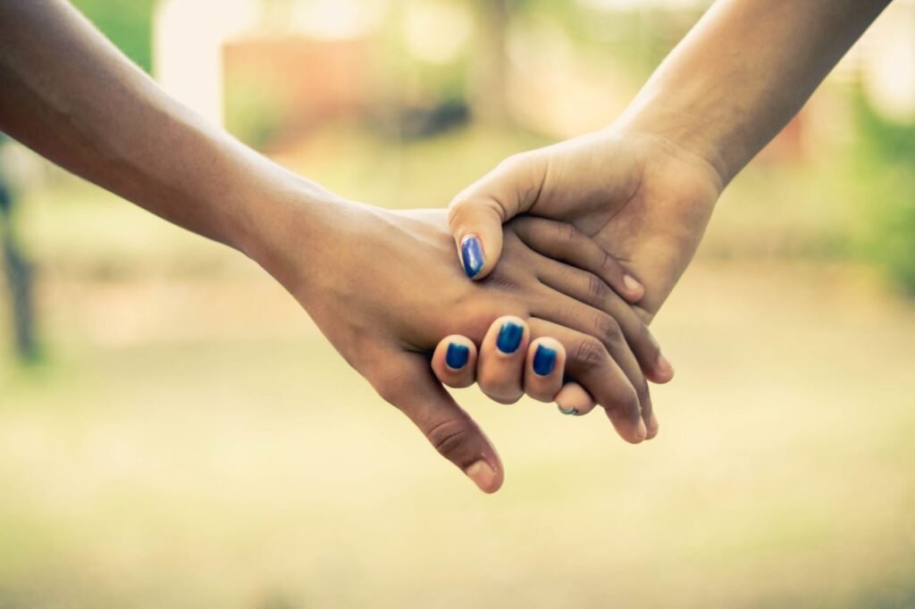 A close-up image of two people holding hands, conveying unity and support.