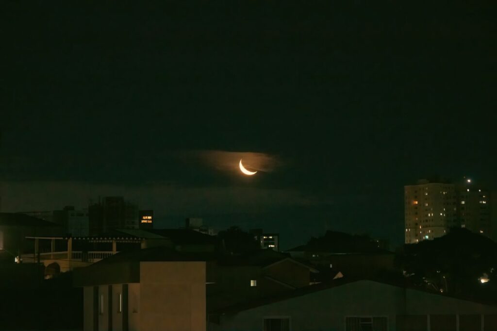 Stunning crescent moon shining above São Paulo's cityscape, capturing a serene night scene.