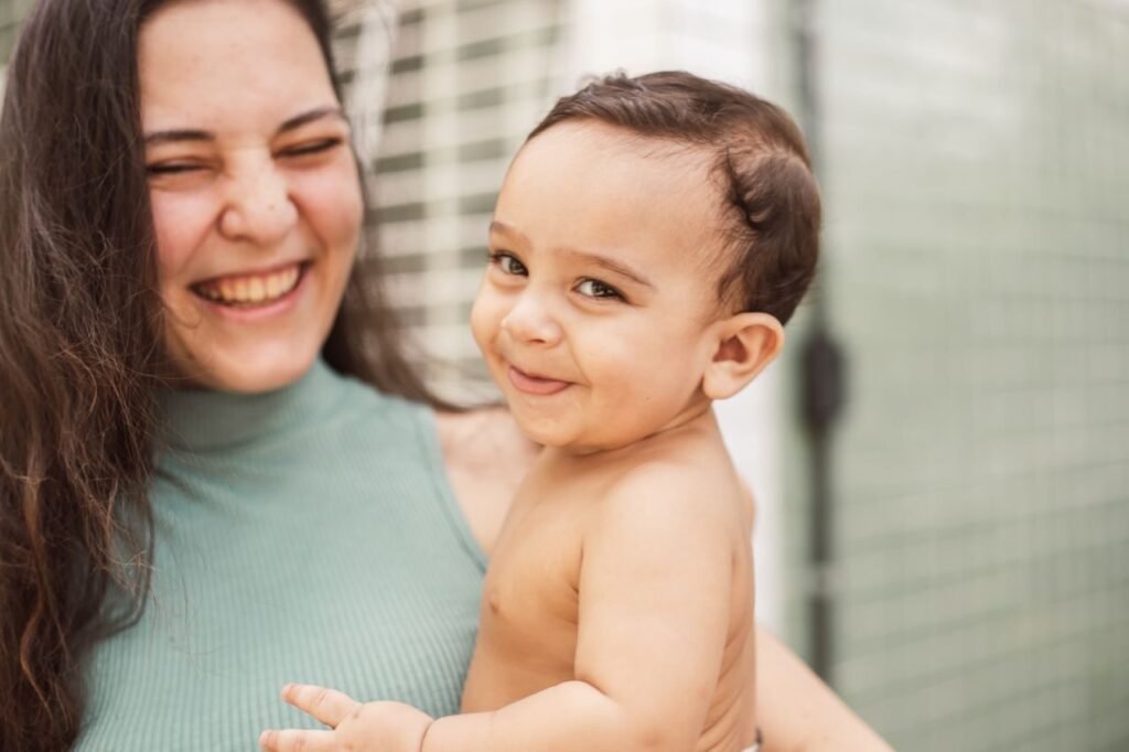 A heartwarming image of a mother and baby sharing a joyful, affectionate moment indoors.