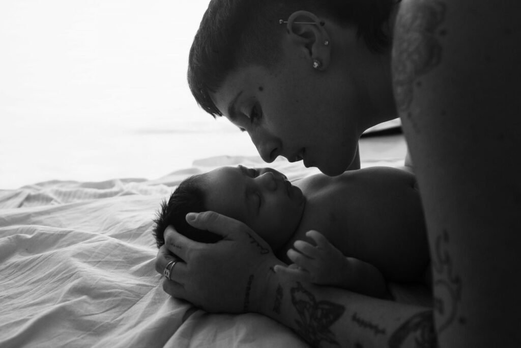 A touching black and white photo capturing a tender moment between a mother and her baby.
