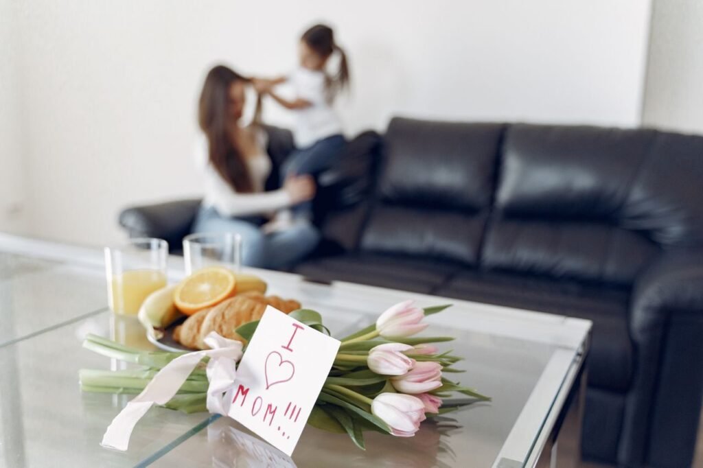 Tulips and a heartfelt note on a table with a mother and child in the background.