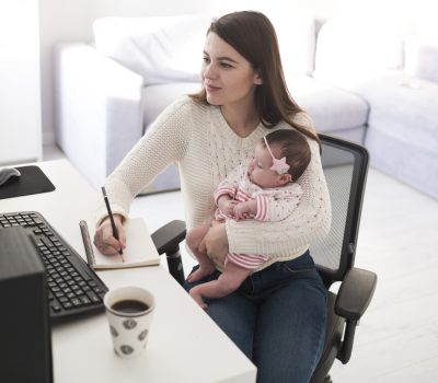 woman-writing-holding-baby